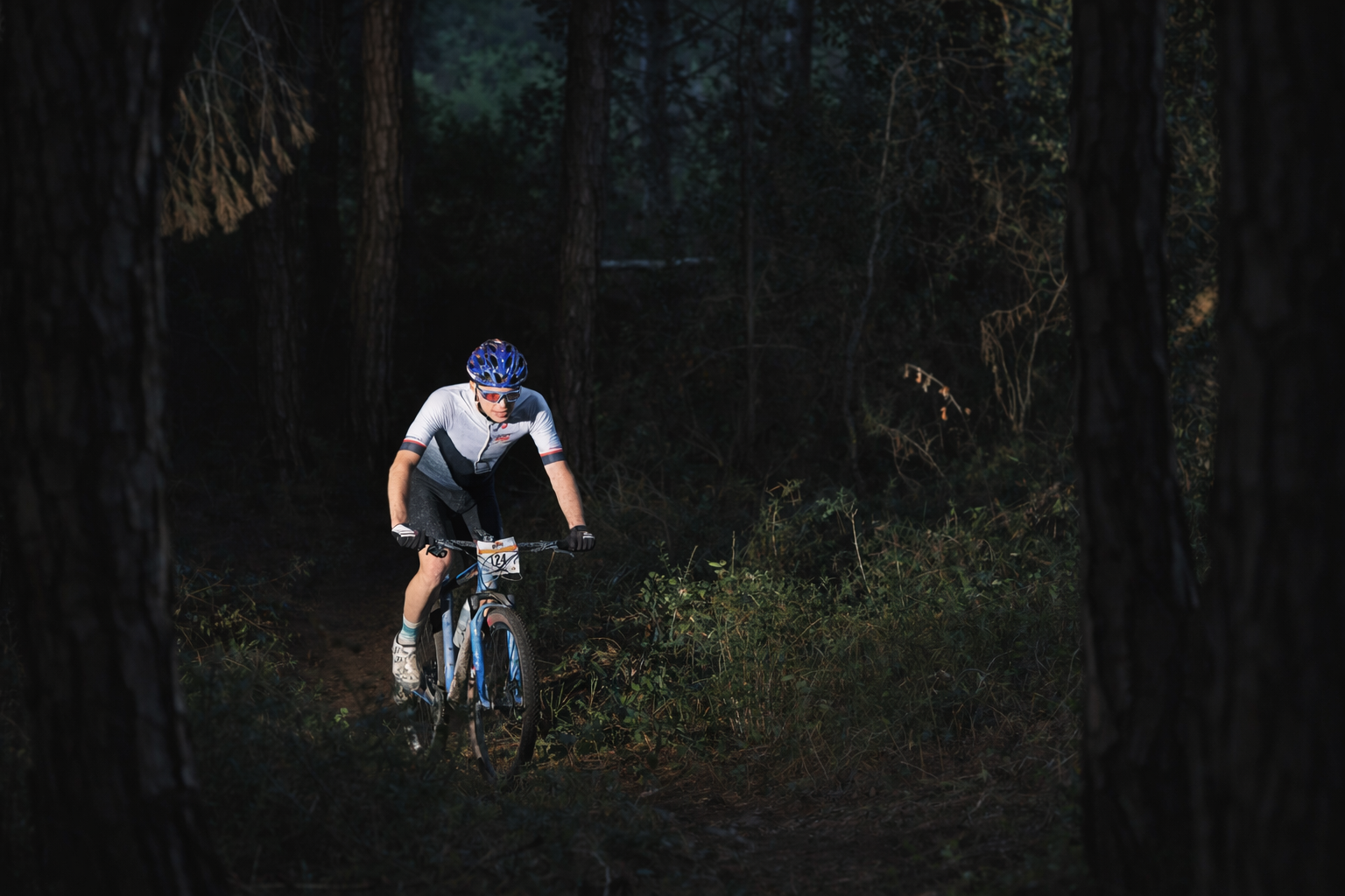 Matthias Temmel auf einem dunklen Waldtrail im Renneinsatz